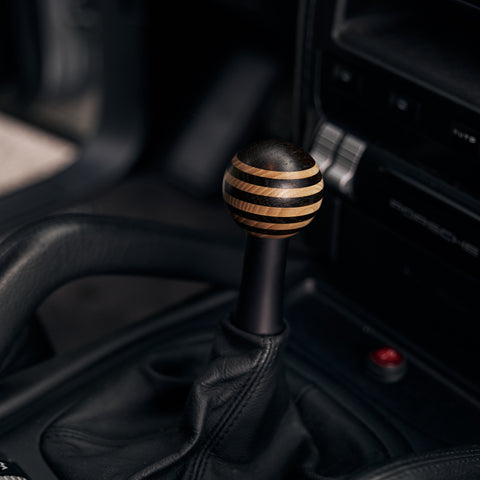 detail view of a wooden gear knob with weng and oak layers in a porsche 964